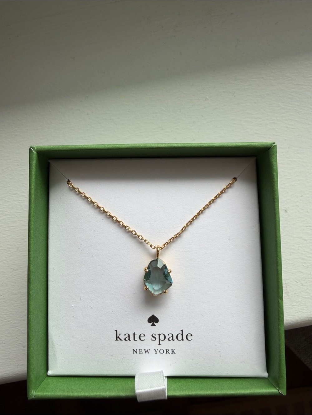 kate spade gold necklace with light blue stone pendant